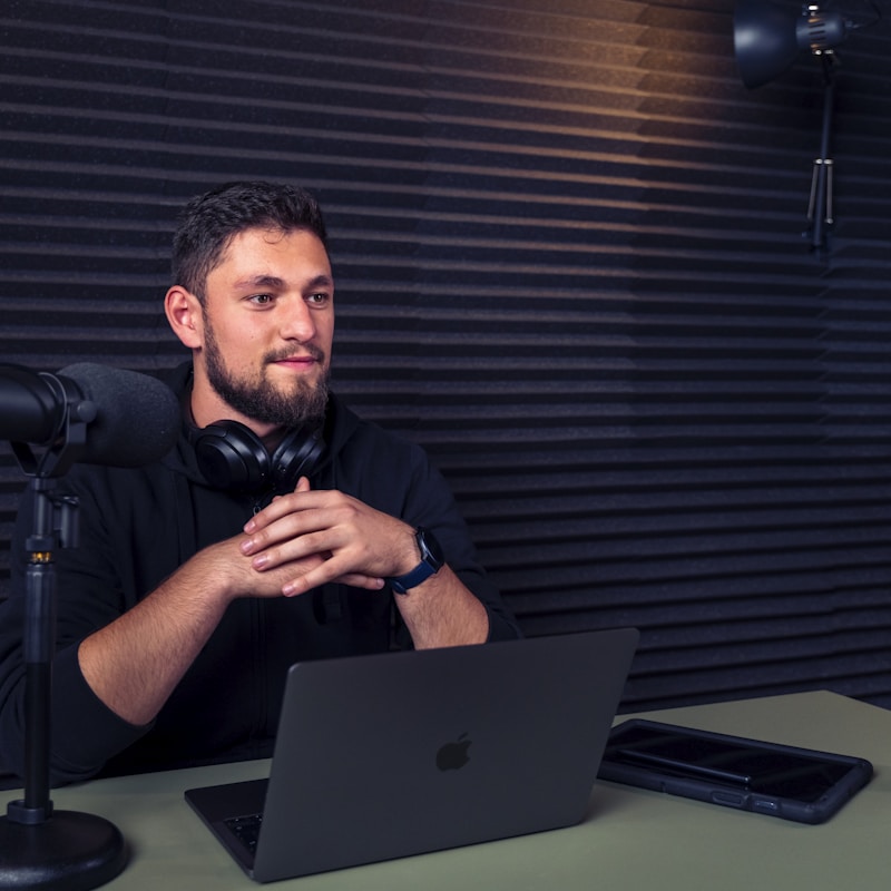 Producer at a desk with a laptop and studio microphone